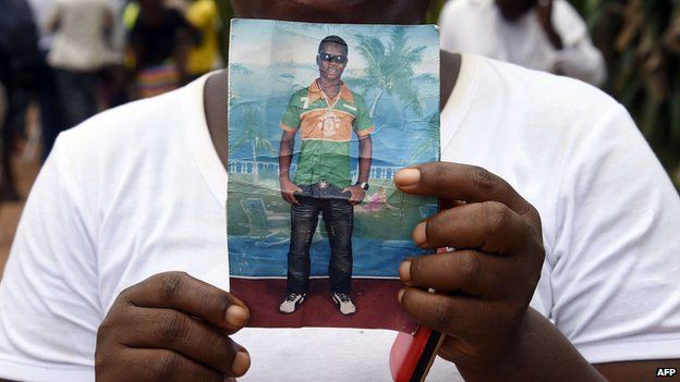 Liberian mother Mary holds a picture of her son Emaya, 20, who is suffering from Ebola and being treated at Island Hospital in Monrovia on September 26, 2014