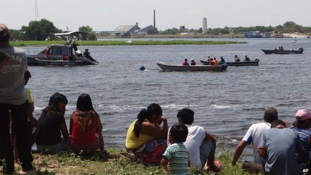 Onlookers follow River Paraguay rescue work, 25 Sep 14