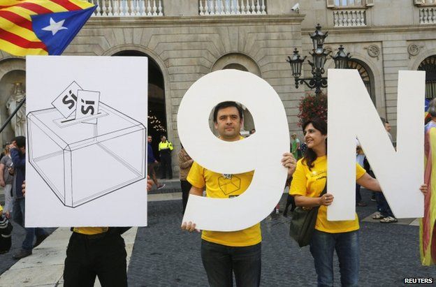 Catalan separatists hold placards in Barcelona to promote the proposed 9 November vote, 27 September
