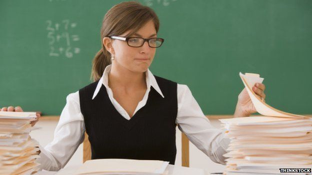 Teacher with pile of marking