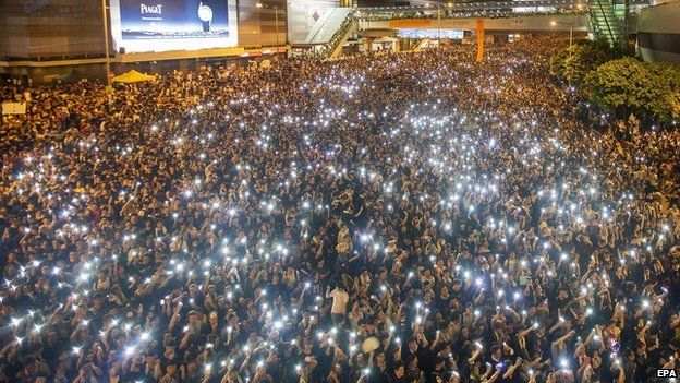 Pro-democracy protesters flash lights outside the Hong Kong government headquarters, on the second day of the mass civil disobedience campaign Occupy Hong Kong, Admiralty, Hong Kong, China, on 29 September 2014