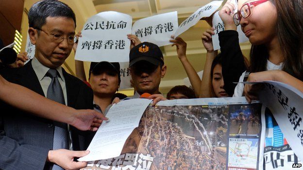John Leung, director of Hong Kong Trade Office in Taipei, receives a protest letter and a newspaper during a demonstration at the lobby of the Hong Kong office in Taipei on 29 September, 2014