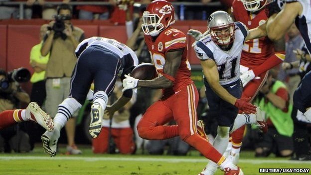 Husain Abdullah (Number 39) returns an interception for a touchdown against New England Patriots quarterback Tom Brady (Number 12) in the second half of the NFL football game in Kansas City.