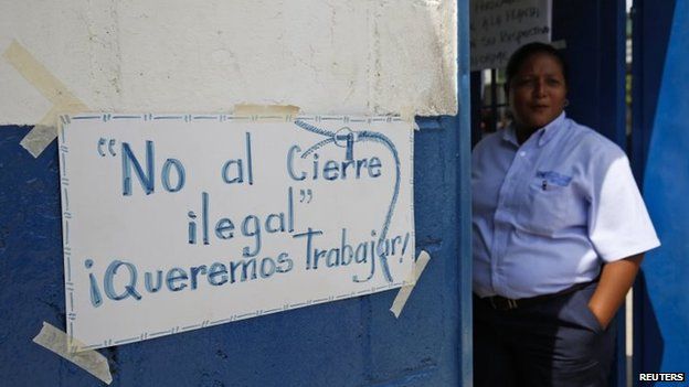 A Clorox worker stands next to a sign on a door at the company headquarters in Valles del Tuy, in Miranda state on 26 September, 2014.