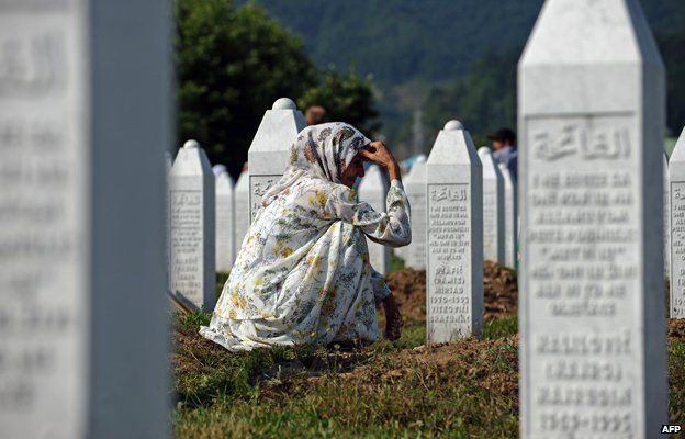 A Bosnian Muslim woman at the grave of her relatives who were killed at Srebrenica