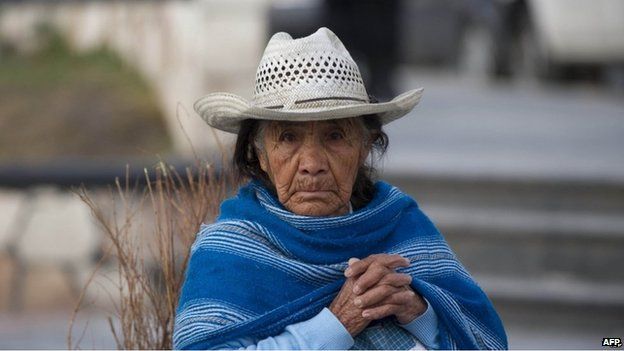 An older Mexican woman looks at the camera