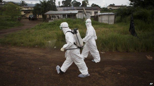 Health workers in protective suits in Sierra Leone