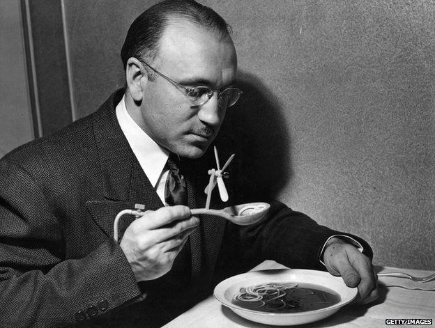 A man eating soup with a spoon with a fan on it