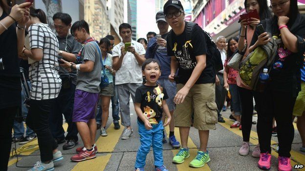A father stands next to his son as he shouts pro-democracy slogans at a protest site in Hong Kong on 1 October 2014.