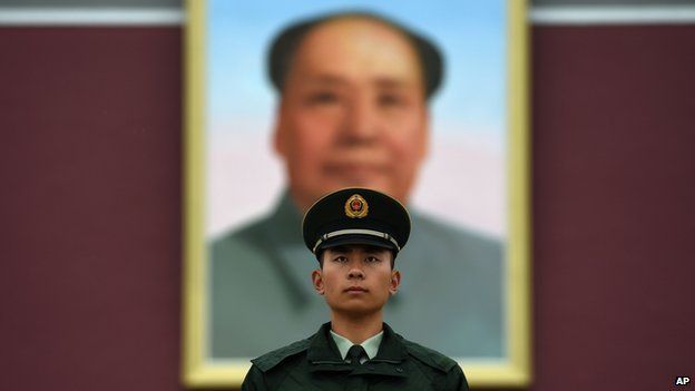 A paramilitary police officer stands guard in front of the portrait of late communist leader Mao Zedong on Tiananmen Gate in Beijing on China's National Day, on 1 October, 2014