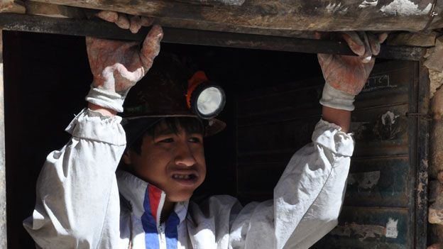 Young miner, Luis, chews coca before work