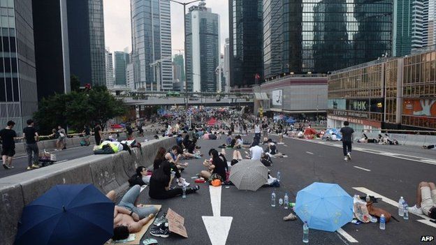 Pro-democracy demonstrators rest after overnight protests near the Hong Kong government headquarters on 2 October 2014