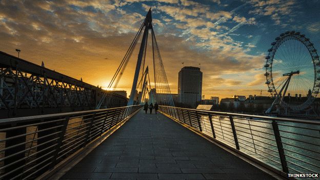 People walking across a bridge in London