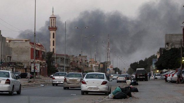 Smoke billows from buildings during clashes between Libyan security forces and armed Islamist groups in the eastern coastal city of Benghazi on 23 August 2014