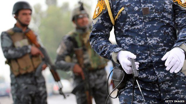 A member of the Iraqi security forces monitor a checkpoint using a fake explosive detecting device in the al-Jadriyah district of Baghdad on May 3, 2013.