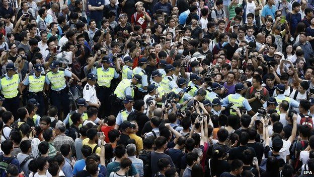 Hong Kong police officers clear the area as they arrest an anti-Occupy Central protester in Mong Kok, Hong Kong - 4 October 2014