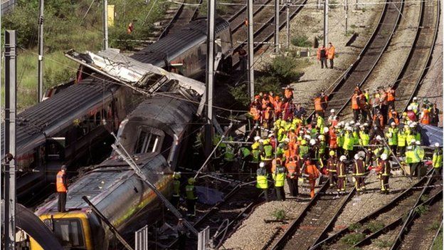 Rescue workers surrounding the wreckage of two trains which lie on rails in west London after a crash near Paddington Station