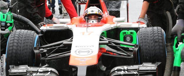 Crew members of Marussia driver Jules Bianchi push his car to the grid