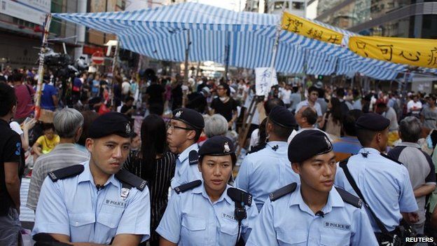 Policemen stand in front of protesters on a main road in Mong Kok district in Hong Kong - 5 October 2014