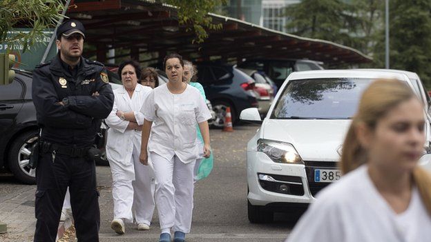 Hospital staff and police outside Carlos III hospital in Madrid, Spain. 7 Oct 2014