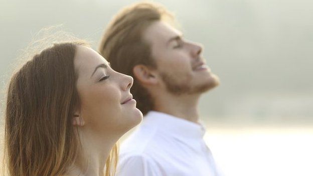 A man and woman looking up to the sky with a calm look on their faces