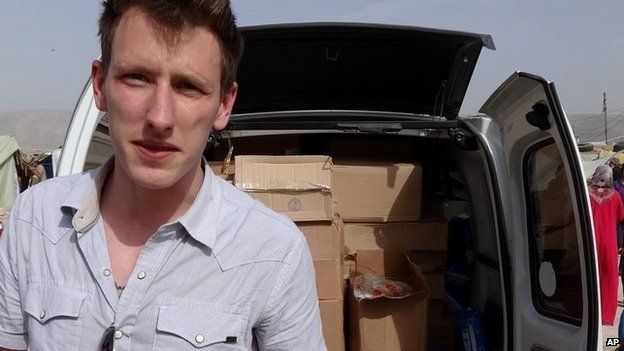Undated photograph of Peter Kassig standing in front of a truck filled with supplies for Syrian refugees