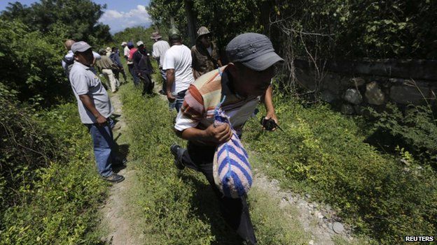 Members of the Public Safety System, the community police of Guerrero state, help in the search for the missing 43 students outside Iguala in the southern Mexican state of Guerrero (8 October 2014)