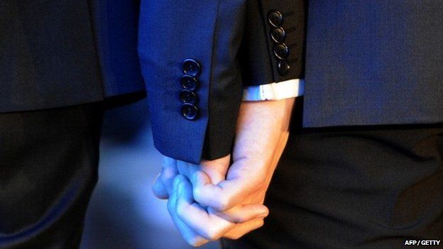 A same-sex couple hold hands