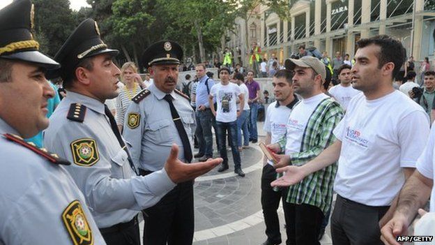 Rasul Jafarov (R) faces police in Azerbaijan on 23 May 2012
