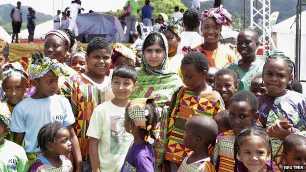 Pakistani schoolgirl activist Malala Yousafzai poses for a photo with children attending a workshop, during her visit to the Emancipation Village at Queen"s Park Savannah, in Port of Spain