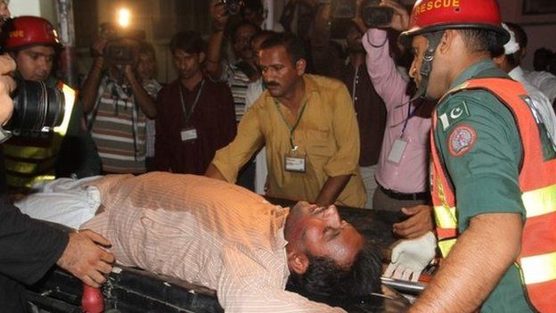 Pakistani rescue workers take an injured person to a local hospital in Multan, Pakistan on 10 October 2014