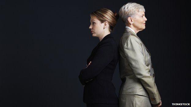 Two businesswomen stand back to back