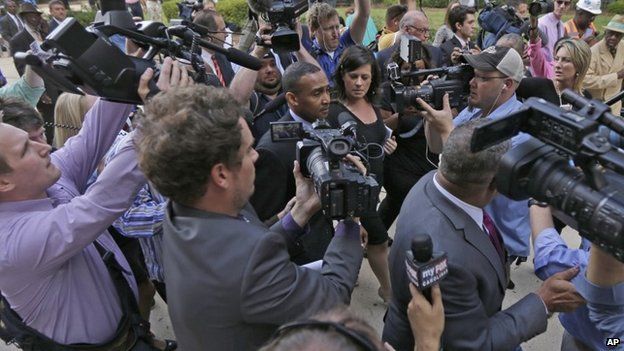 Former Charlotte Mayor Patrick Cannon, center, is surrounded by media as he leaves the federal courthouse in Charlotte, North Carolina, 14 October 2014