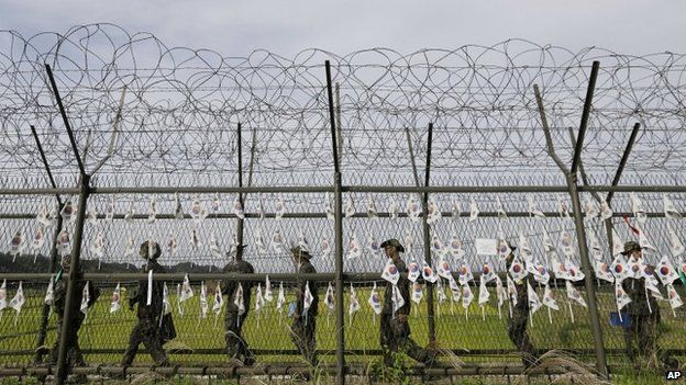 South Korean army soldiers patrol through the military wire fences with hanging South Korean national flags at the Imjingak Pavilion near the border village of Panmunjom, which has separated the two Koreas since the Korean War, in Paju, South Korea, on 17 September 2014