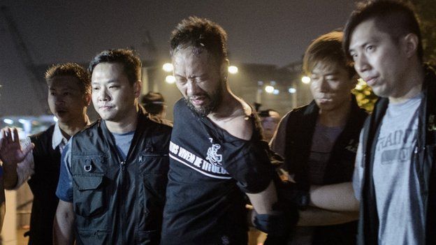 Civic Party member Ken Tsang, one of Hong Kong"s pro-democracy political groups, is taken away by policemen, before being allegedly beaten up by police forces