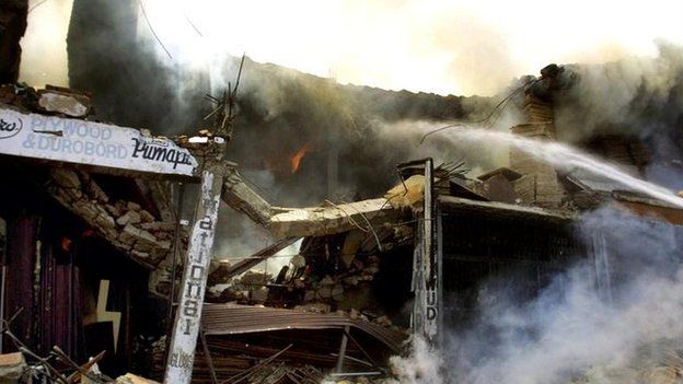 A destroyed two-story Bank of Rajasthan buidling is seen on fire near Jullundur, India, Friday May 3, 2002, after an Indian Air Force MiG-21 jet crashed into the building.