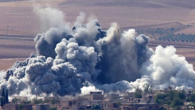 Smoke billows over a village near Kobane