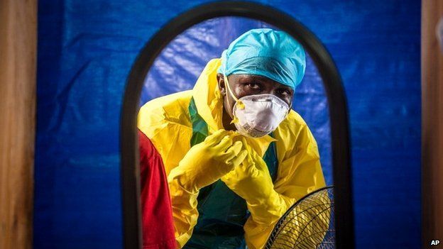 A medical worker dons protective gear before entering an Ebola treatment centre in Freetown, Sierra Leone - 16 October 2014