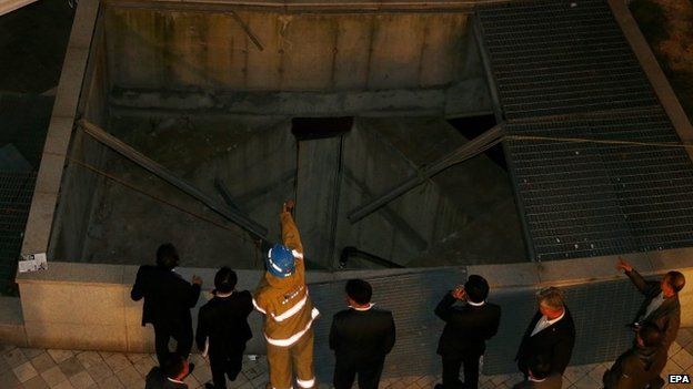Officials inspect the collapsed ventilation grate in Seongnam City, South Korea on 17 October 2014.