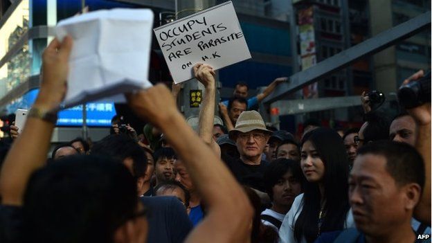 A man holds a note protesting against pro-democracy demonstrators in front of a barricade in Mong Kok district in Hong Kong, 18 October 2014
