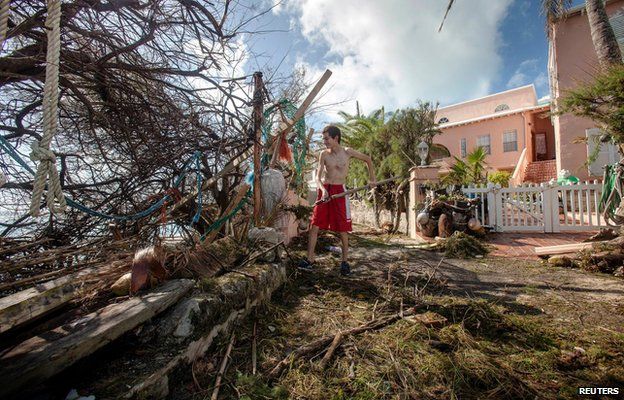 Stefano Ausenda shovels debris away from his driveway after Hurricane Gonzalo passed through in Sandys Parish, western Bermuda, October 18, 2014