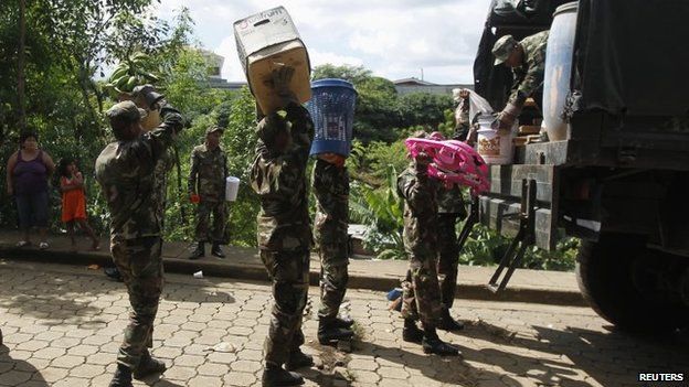 Nicaraguan Army personnel carry belongings from residents displaced by heavy rains, which caused flooding and landslides in the capital Managua Oct 18 2014