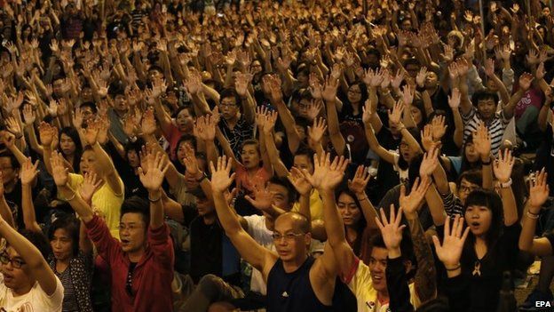 Pro-democracy advocates raise their hands in a symbolic show of peace and non-violence, during a rally of the ongoing Occupy Central movement at Admiralty district of Hong Kong, 19 October 2014