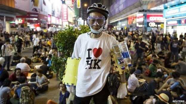 A pro-democracy protester wearing a helmet, goggles and foam pads poses for a picture on a blocked road at the Mong Kok shopping district in Hong Kong, 19 October 2014