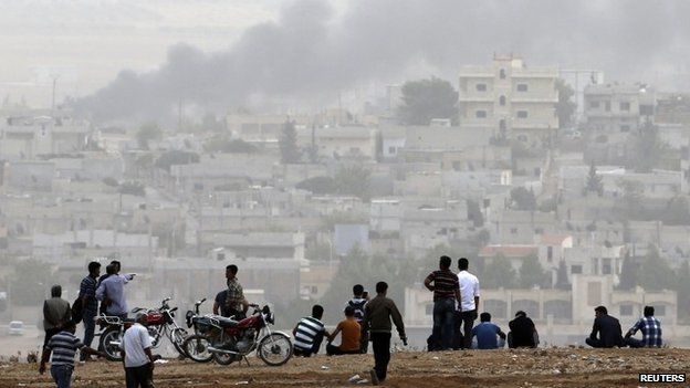 Kobane, Syria, in the background as Turkish Kurds in Turkey watch the fighting there, 11 October 2014
