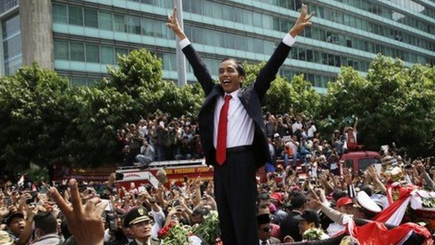 Indonesian President Joko Widodo gestures to the crowd during a street parade following his inauguration in Jakarta, Indonesia, 20 October 2014