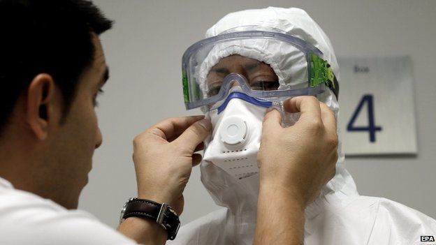 Woman having mask and protective clothing fitted