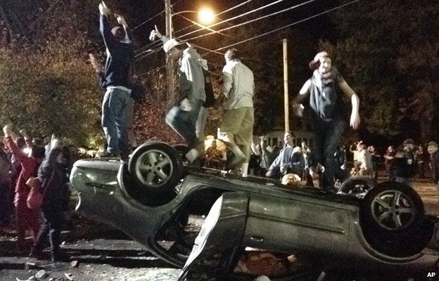 Students on a upturned car in Keene, New Hampshire