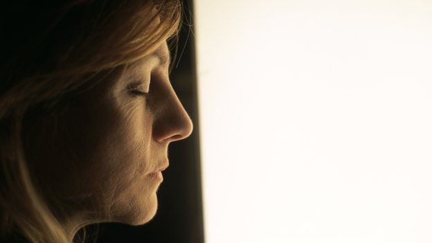 Woman standing by a light box