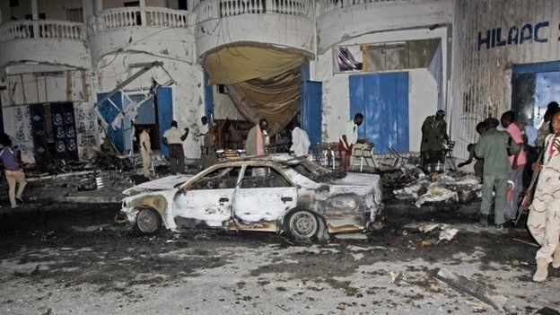 Somali security forces and others attend the scene of a car bomb attack in the capital Mogadishu, Somalia, (12 October 2014)